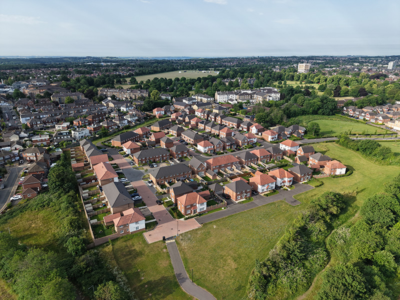 default Aerial view of a new housing development on the edge of a town, bordered by green open space