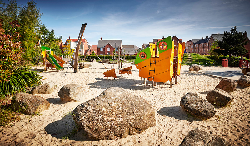 values-2 Children's play area with wooden play equipment and boulders in a new residential neighbourhood