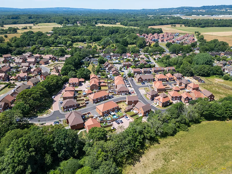 what we do Aerial view of a new housing estate set among woodland and countryside